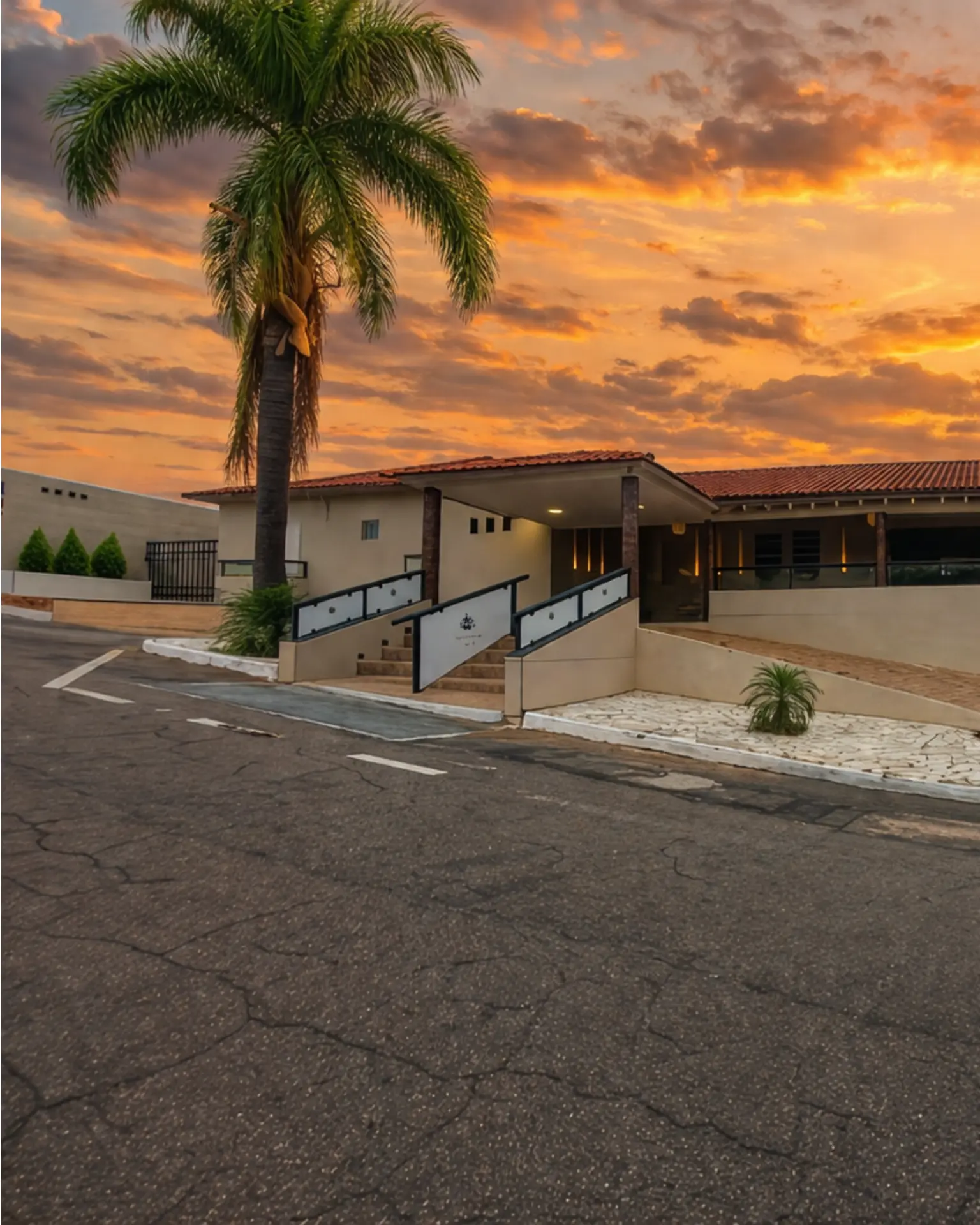 Hotel Veredas ao pôr do sol com palmeira imperial em primeiro plano